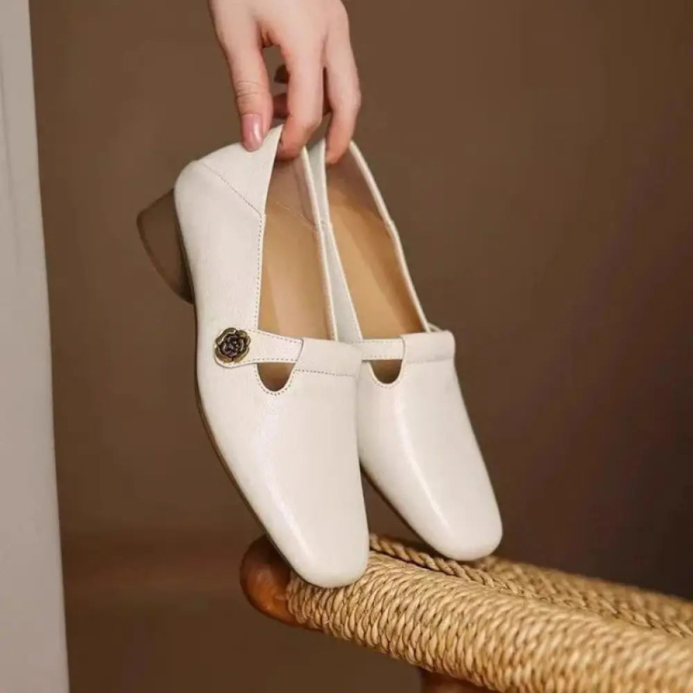 White leather retro loafers with square toe and decorative metallic rose buckle detail