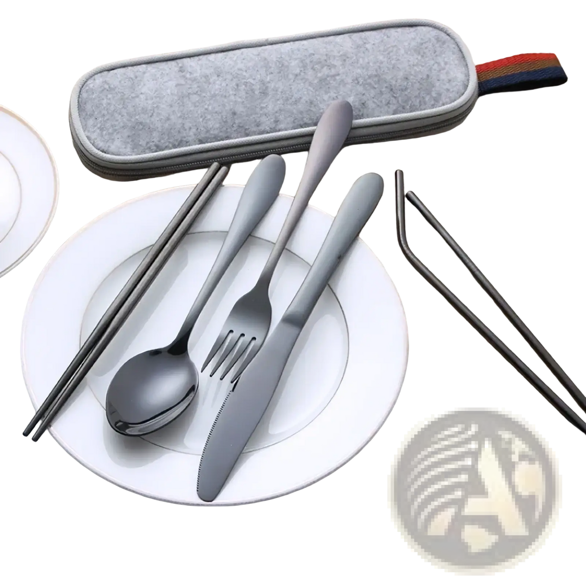 Gray stainless steel reusable travel cutlery set with flatware chopsticks and straws neatly arranged on white plate