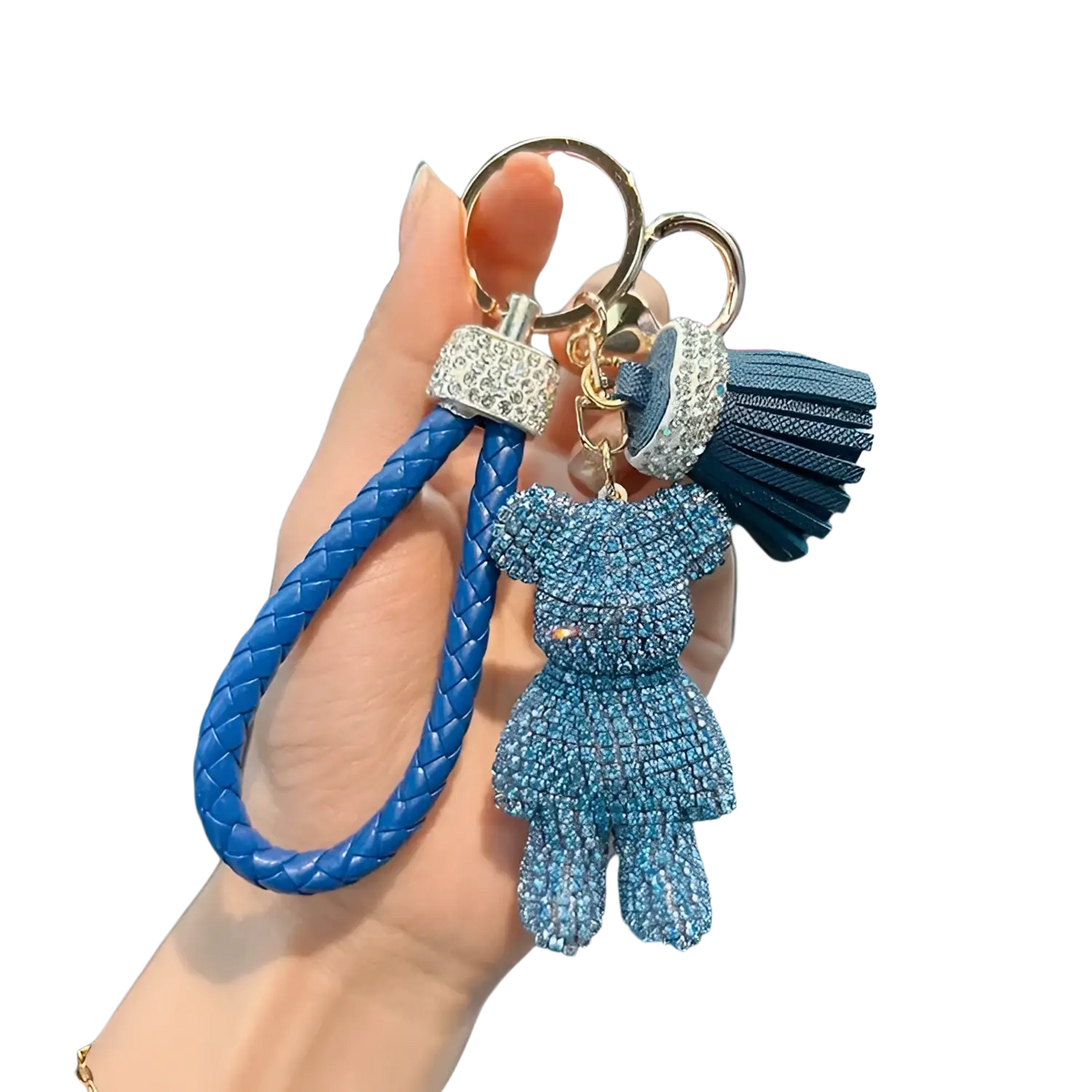 A blue braided leather keychain with a rhinestone-adorned teddy bear charm and matching tassel