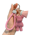 Pink braided leather keychain with rhinestone bear charm and matching tassel for stylish accessory use