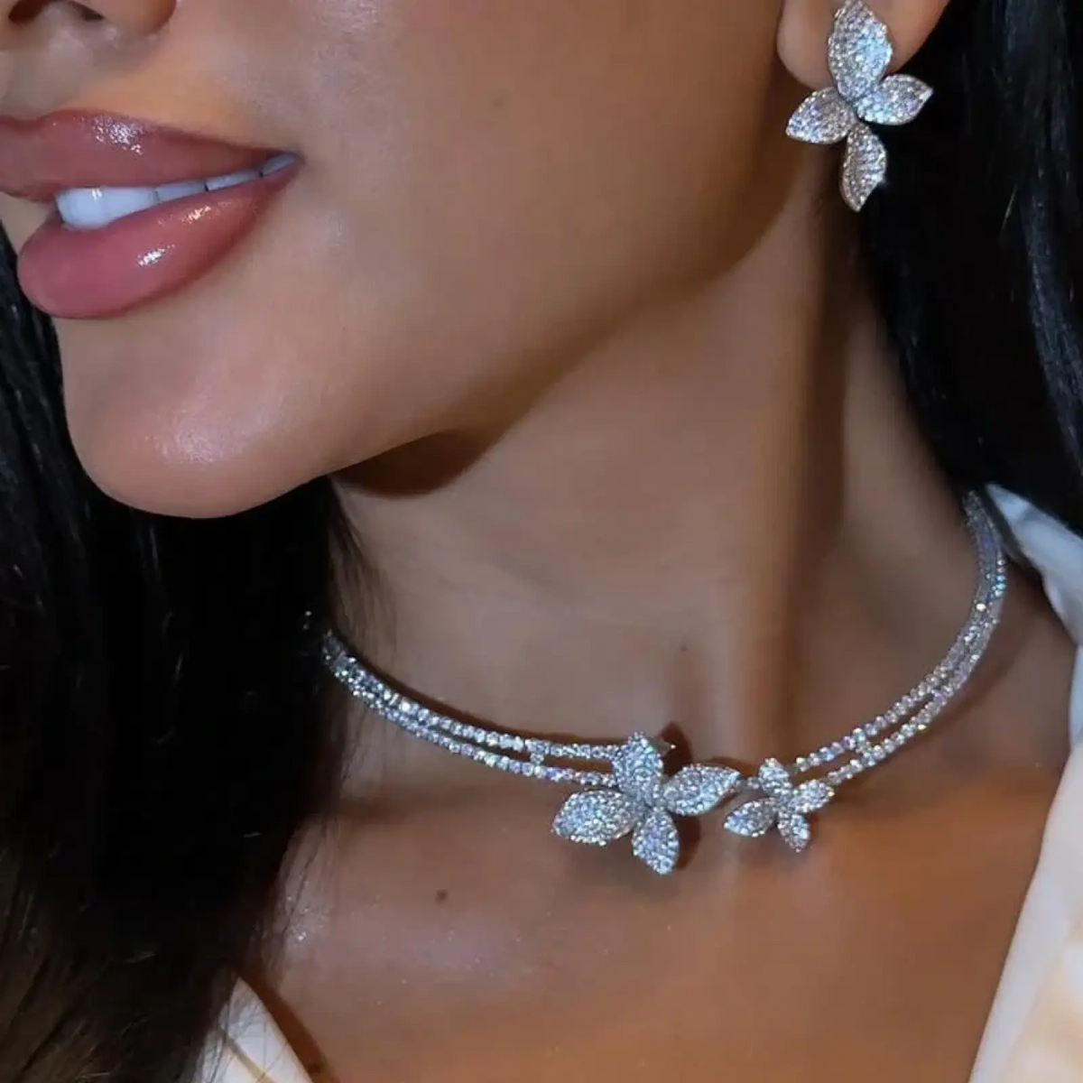 A sparkling silver rhinestone choker necklace with diamond-encrusted butterfly charms from the bridal jewelry set