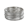Stack of silver rhinestone metal bangles for women with clear sparkling stones along the outer edge