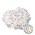 White floral rhinestone wedding ring pillow with silver accents holding a heart-shaped clear case with two gold rings