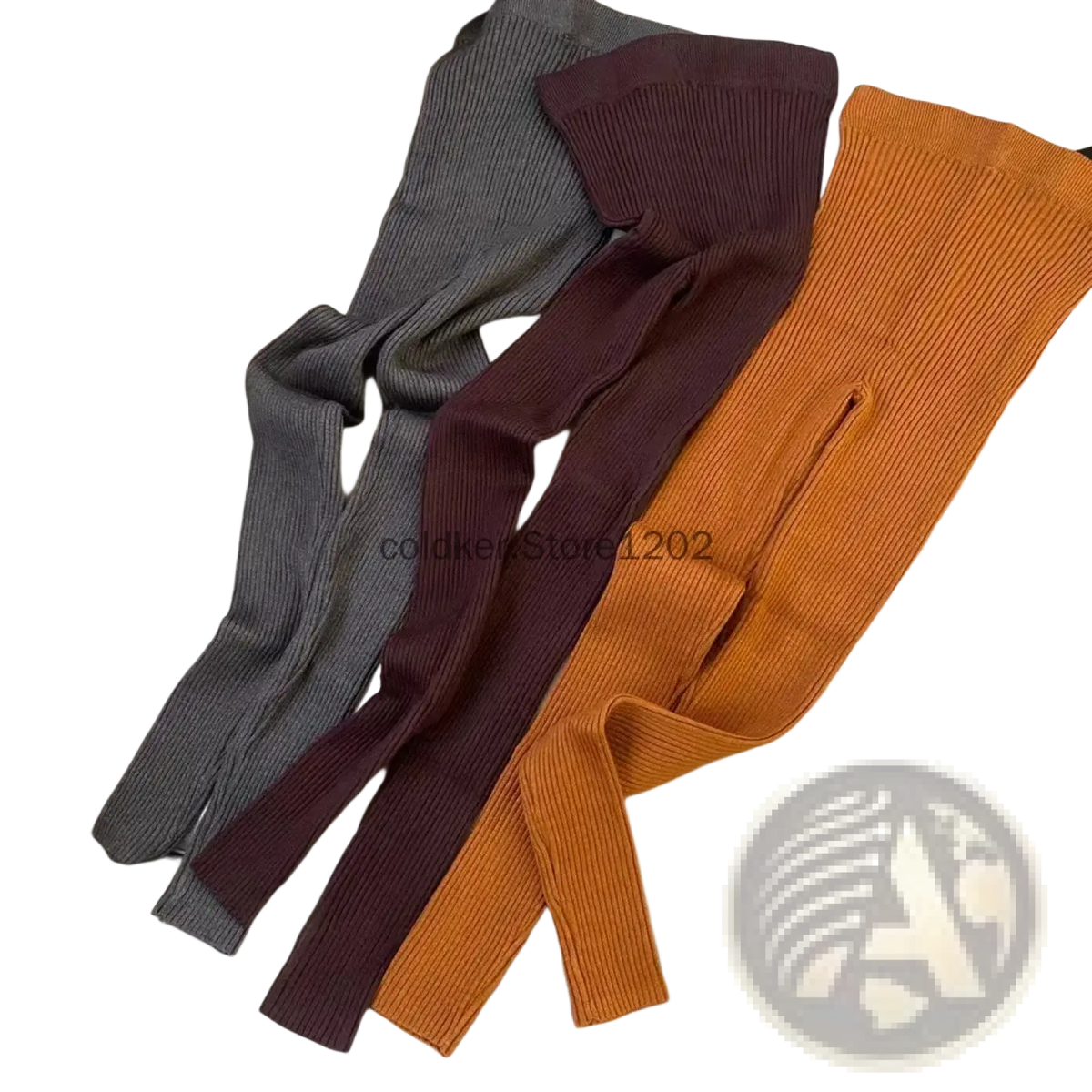 Three ribbed knit leggings high waist winter pants in gray burgundy and orange laid out on a light-colored couch