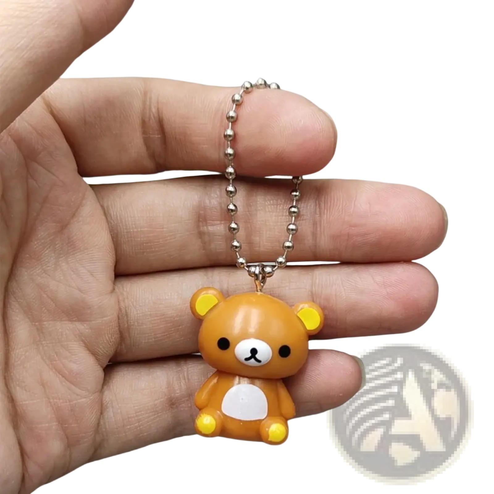 A small orange rilakkuma bear keychain charm with yellow ears paws and a silver ball chain pendant for diy use