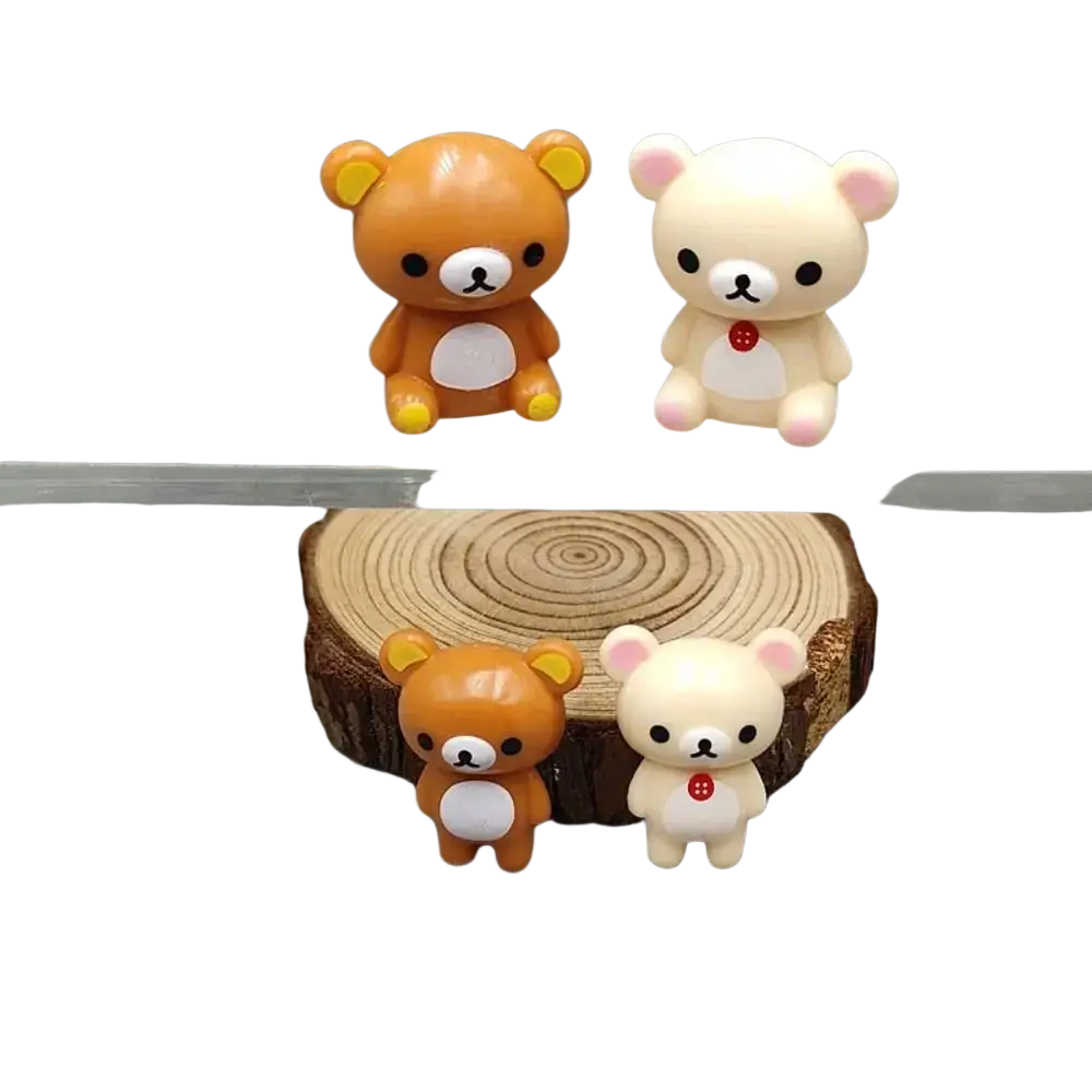 Two adorable rilakkuma bear keychain figurines in warm orange and soft cream with glossy plastic and embroidered details