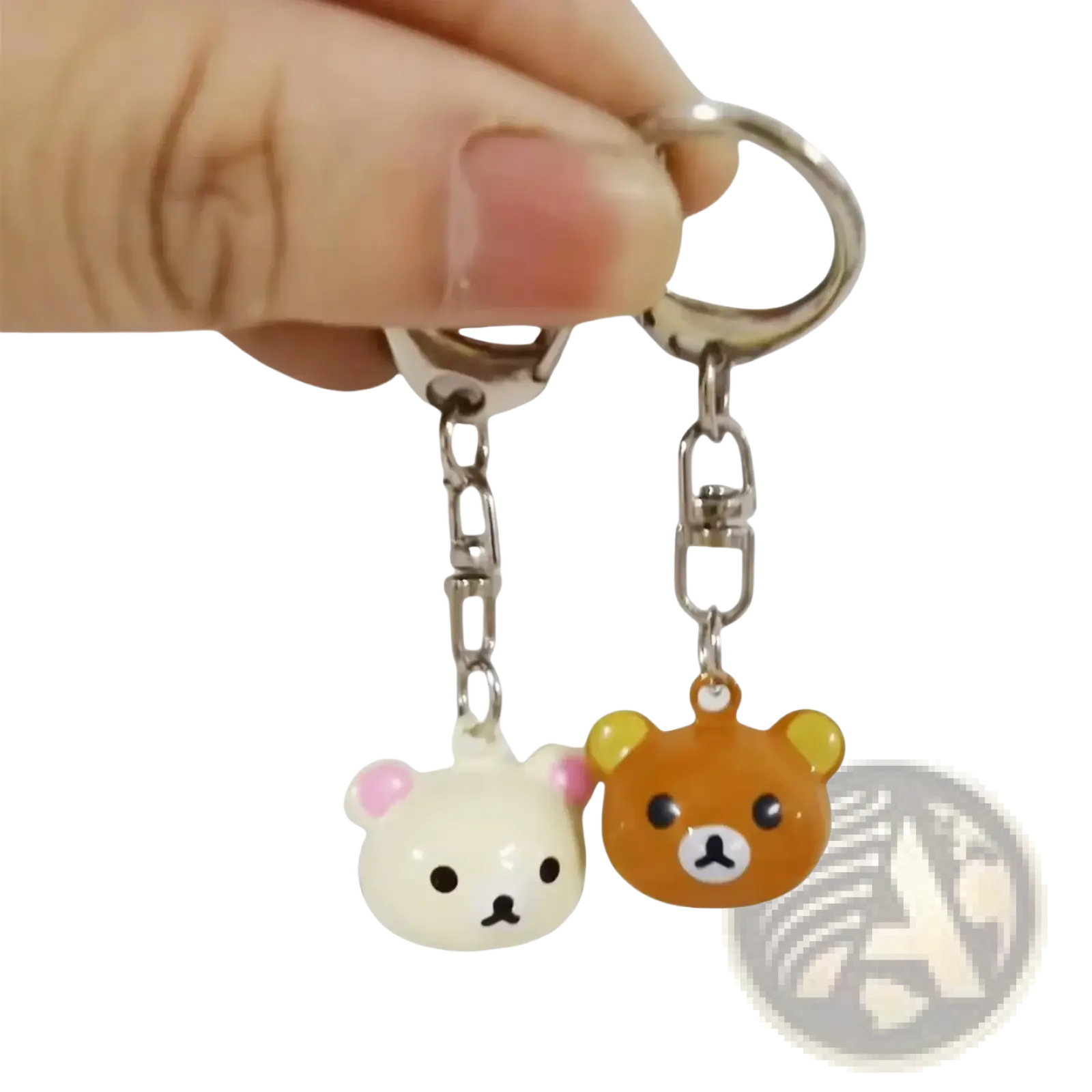 A pair of cute glossy plastic rilakkuma bear keychains in white with pink ears and orange, attached to metal rings