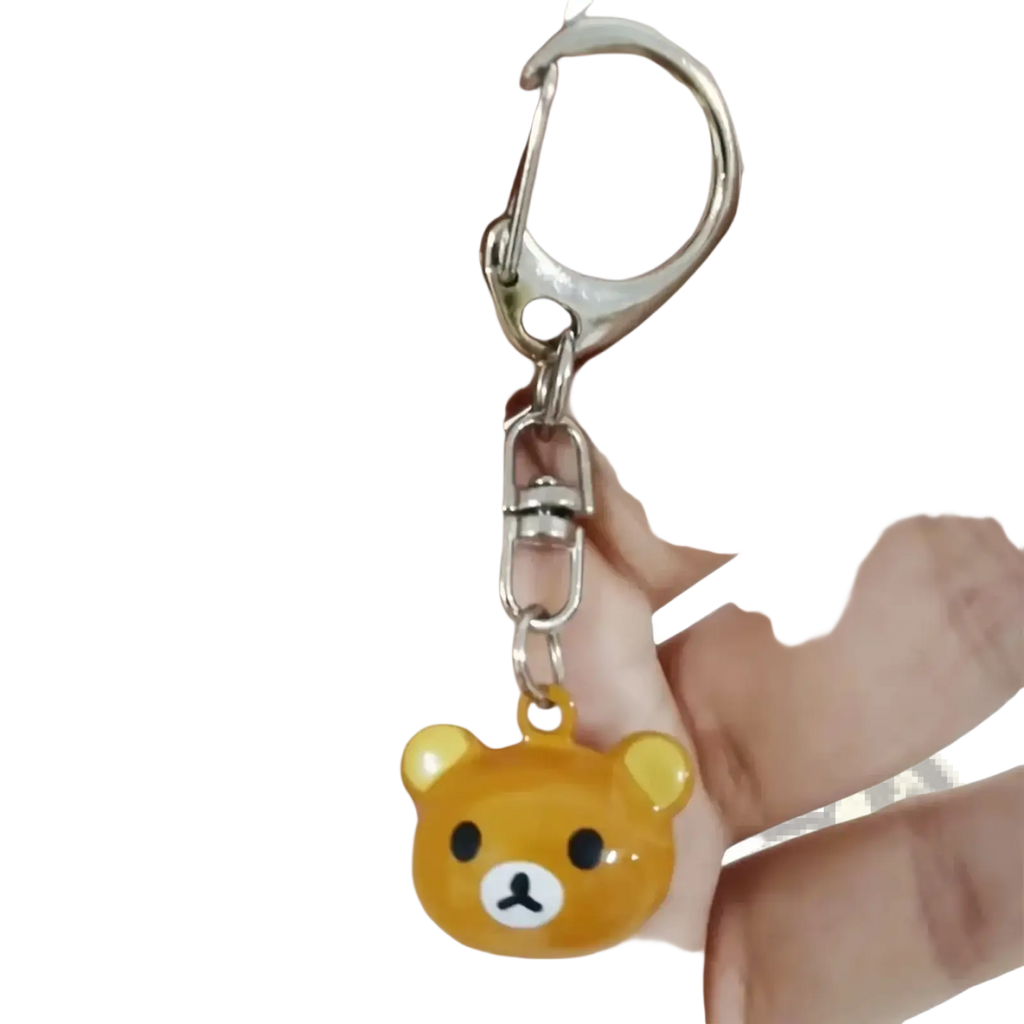 A shiny translucent orange bear-shaped enamel charm keychain with black eyes and a white nose from Rilakkuma set