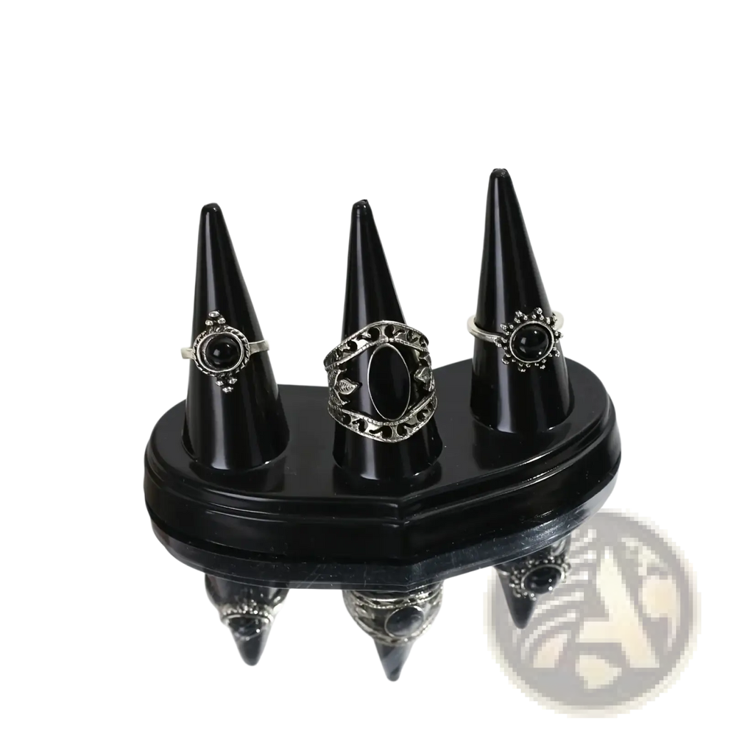 Black plastic conical ring holder display stand with three silver-toned rings featuring black onyx and filigree designs