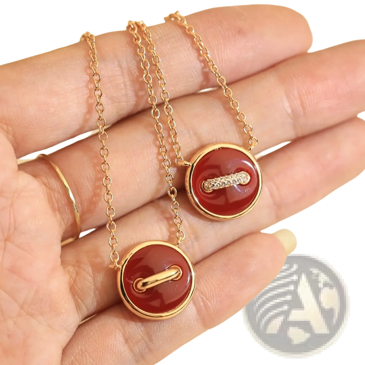 Two gold-toned button-shaped necklaces with red carnelian stones and diamond accents in rose gold double sided sterling silver