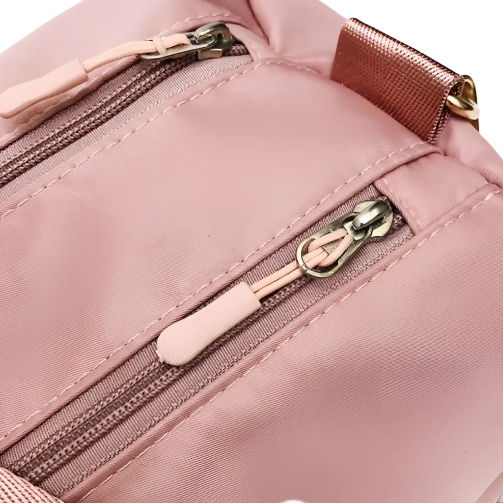 Pink nylon crossbody bag with matching zipper pulls and rose gold metal strap buckle for the rose gold nylon waterproof sports duffel bag