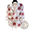 White sheer blouse with red rose print and buttoned flap pockets showcasing elegant lightweight design
