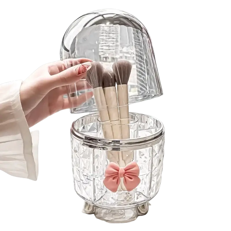 Clear crystal rotating cosmetic makeup organizer with faceted design silver rim feet and pink satin bow makeup storage