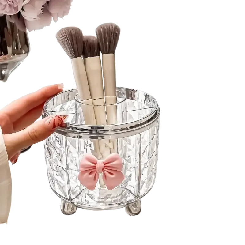 Clear crystal rotating cosmetic makeup organizer with pink bow accent and silver metal feet for makeup storage