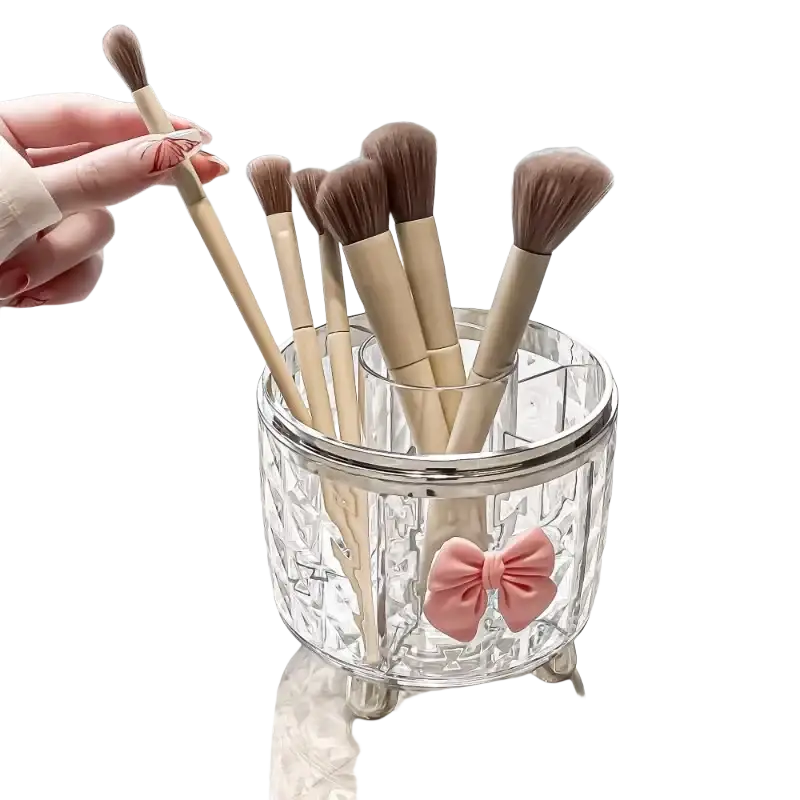 Clear glass brush holder with pink bow and silver trim in rotating cosmetic makeup organizer storage box
