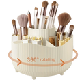 Rotating makeup organizer in cream-colored ribbed plastic with multiple compartments holding brushes and lipsticks