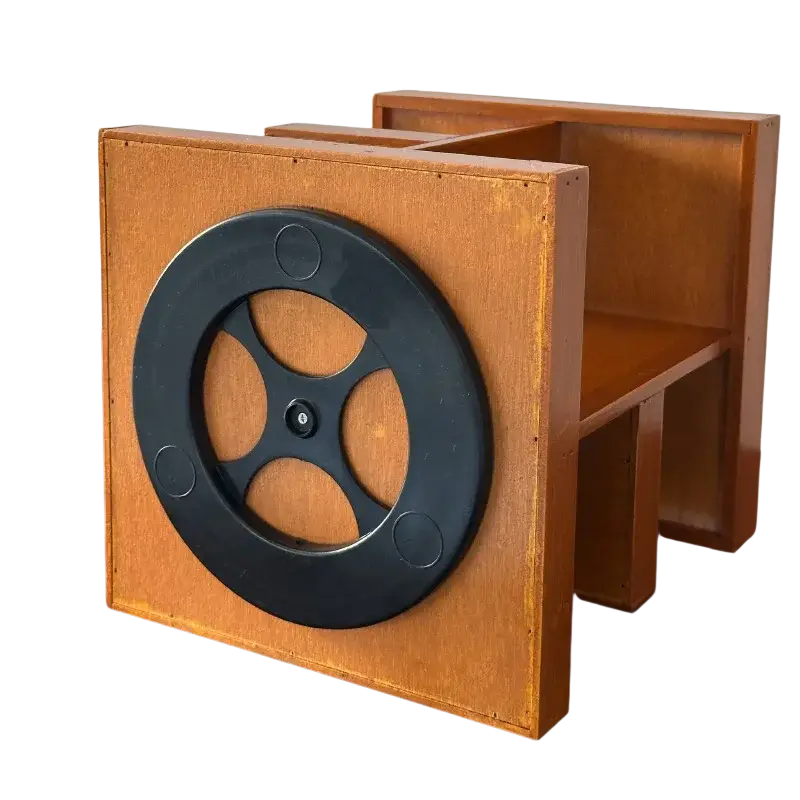Rotating wooden makeup organizer with a black circular film reel mounted on the front on a wooden bookshelf