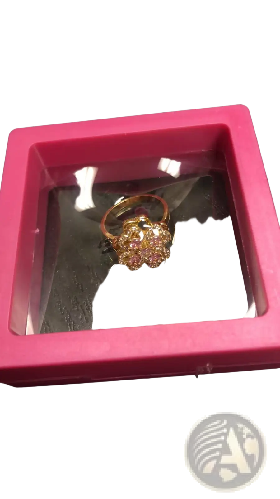 A gold-toned rotating zircon four leaf clover adjustable ring with pink and clear crystals in a pink display case