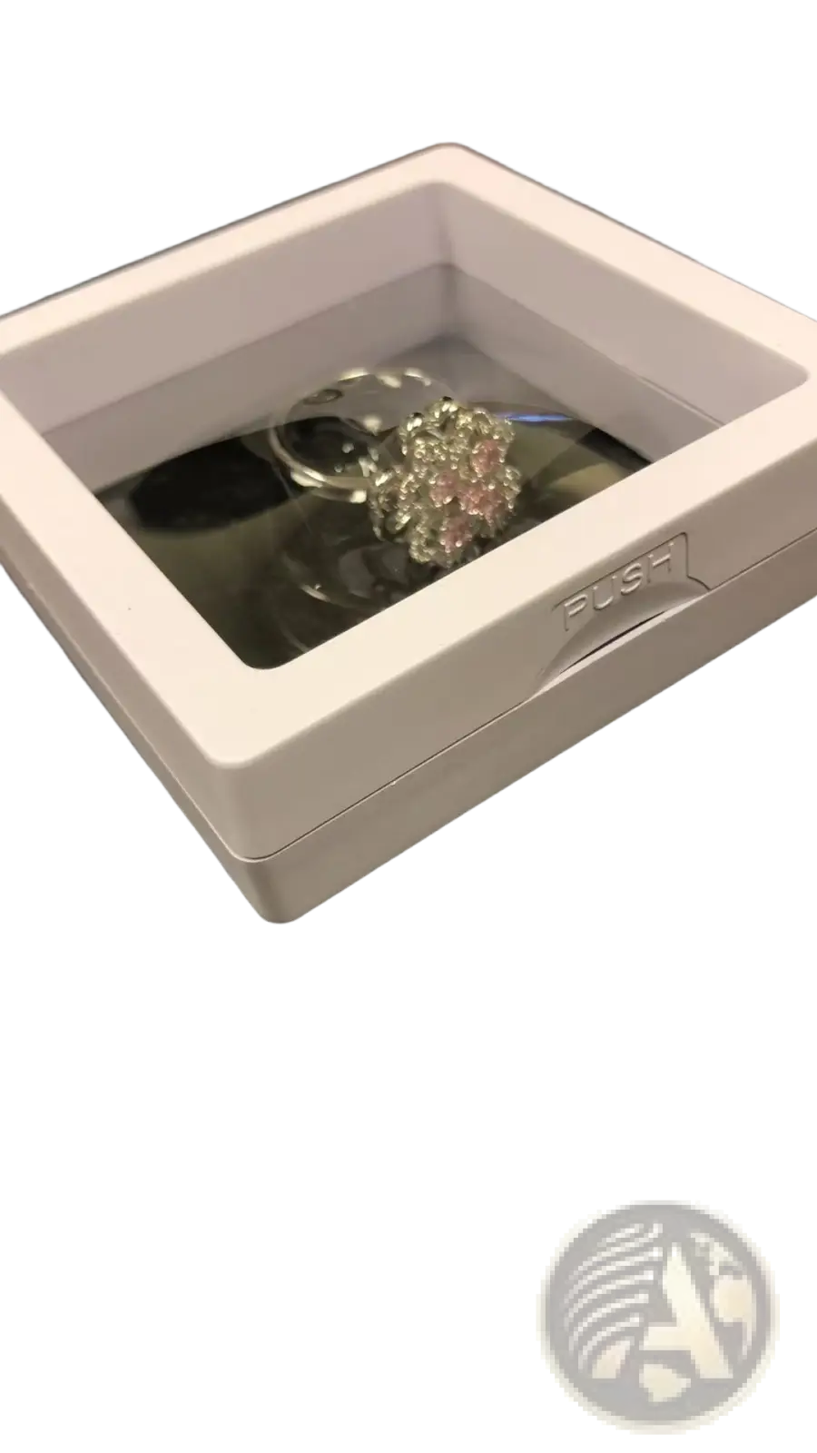 A sparkling silver rotating zircon four leaf clover adjustable ring with clear stones in a white display case