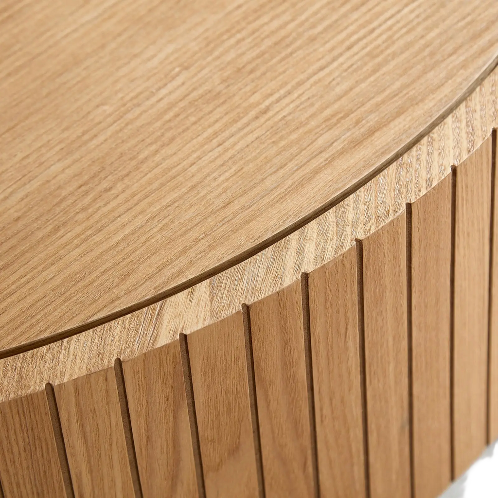 Round coffee table with storage in light oak wood featuring a smooth rounded top and vertical slat detailing
