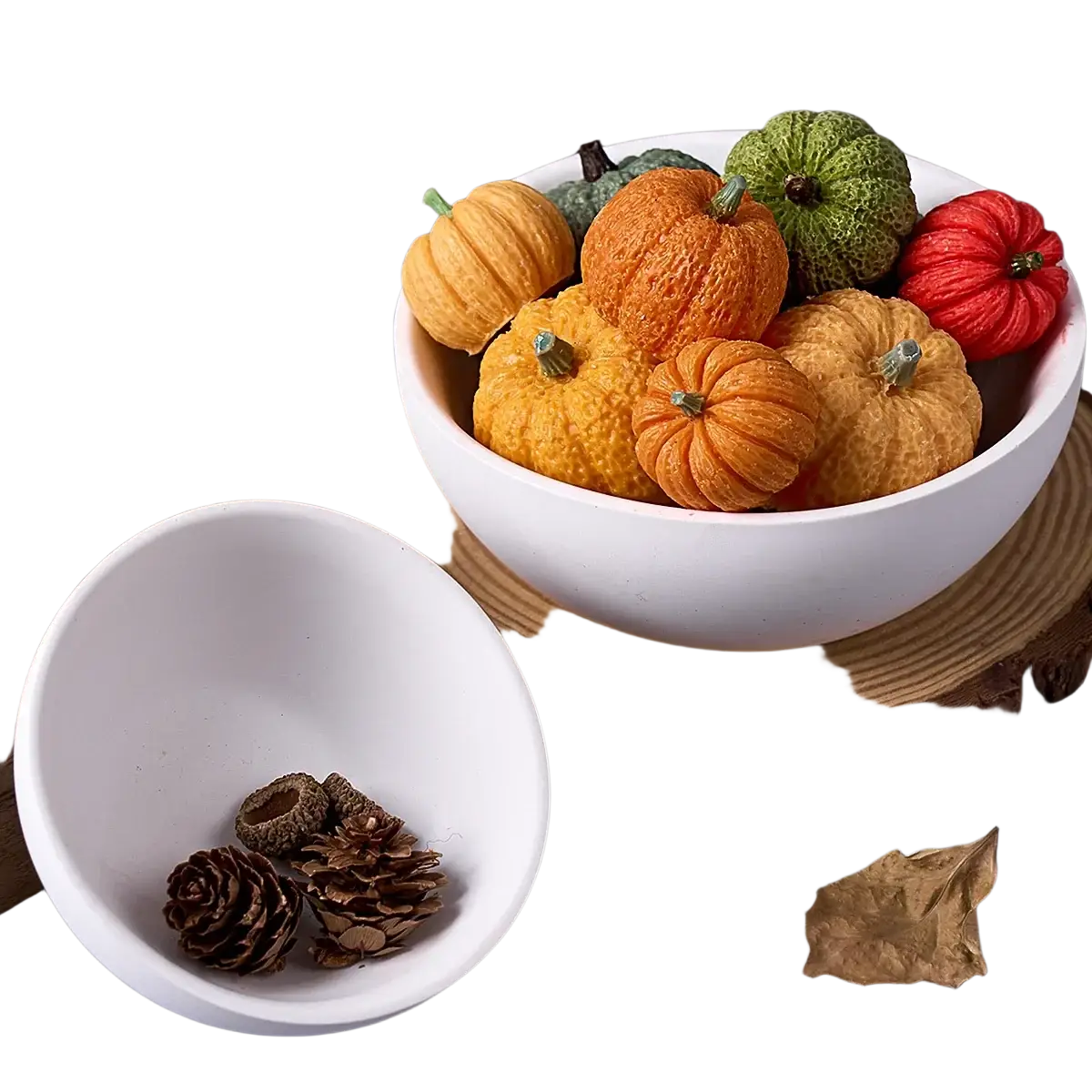 A white ceramic bowl made using a round silicone mold for concrete filled with miniature orange green and red pumpkins