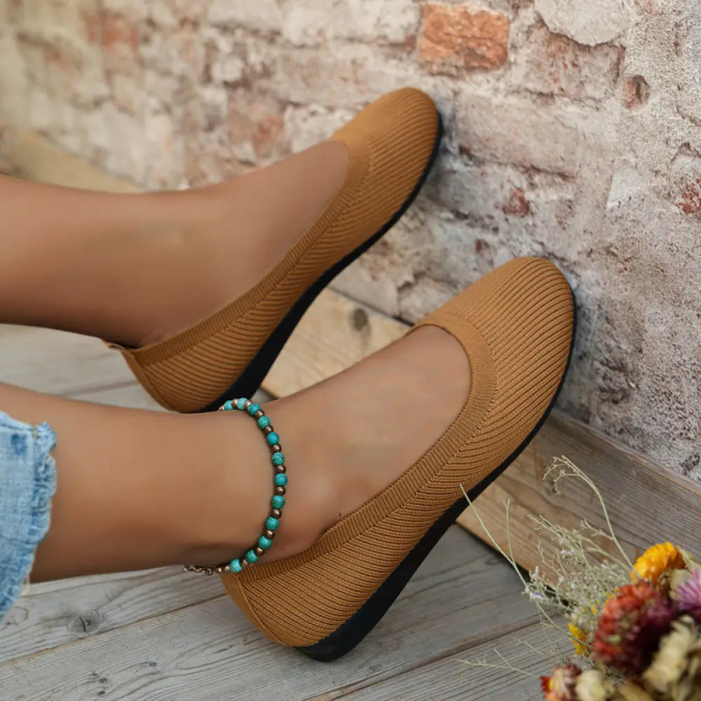 Tan ribbed knit flat shoes with black sole for women featuring round toe and comfortable slip on design