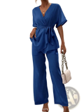 A vibrant royal blue satin wrap jumpsuit with v-neckline short flutter sleeves and self-tie waistband