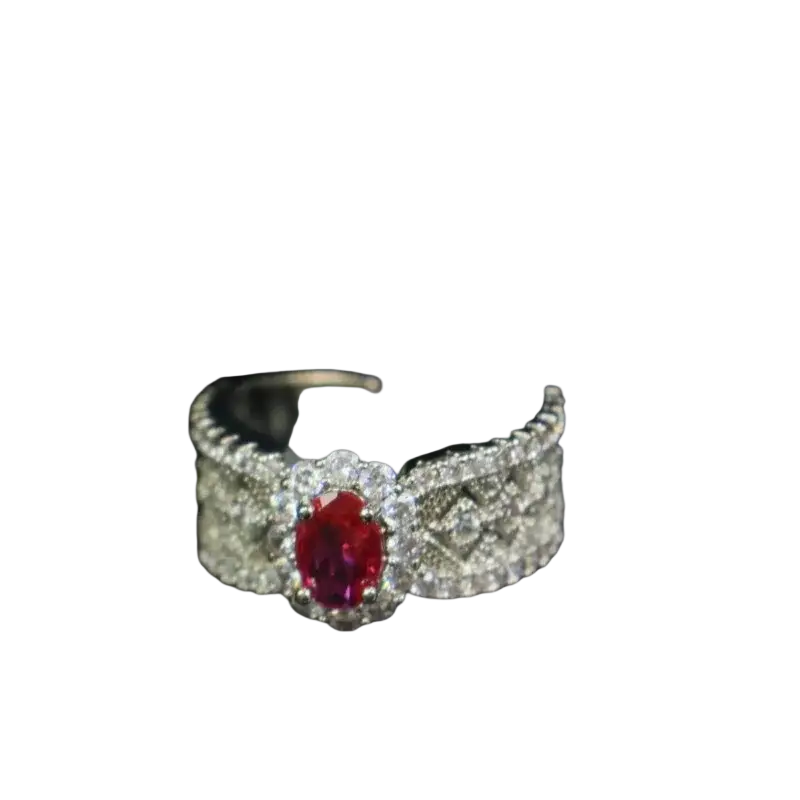 A silver band ruby halo ring with an oval-cut central ruby and diamond pavé detailing on the sides