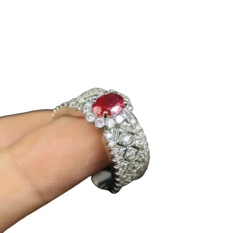 A sparkling silver ruby halo ring with an oval-cut red ruby and diamond pavé band