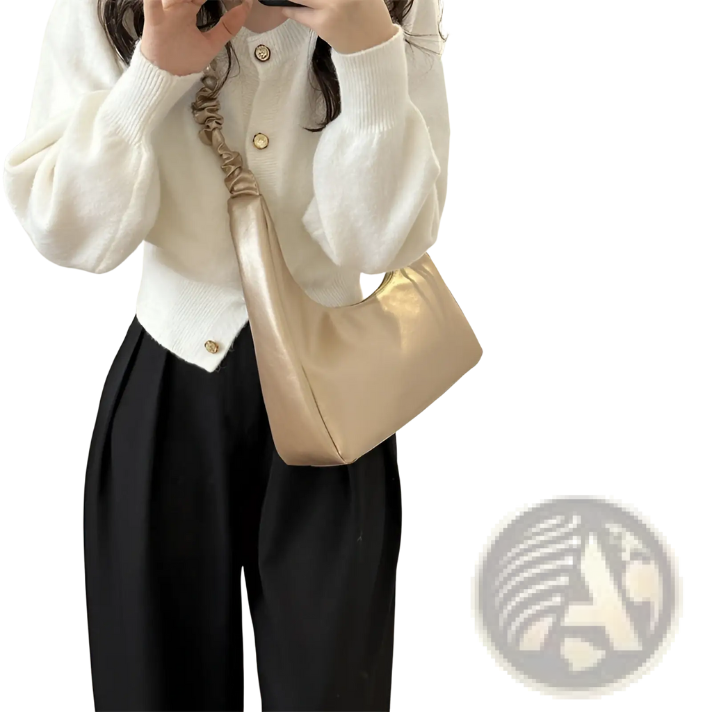A sleek metallic gold ruched shoulder bag made of patent leather with a glossy finish and ruched strap