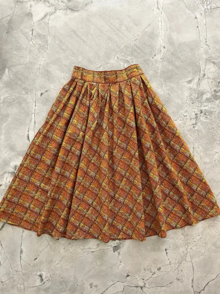 Rust plaid Doris retro a-line cotton skirt with pockets featuring a warm orange and yellow textured fabric pattern