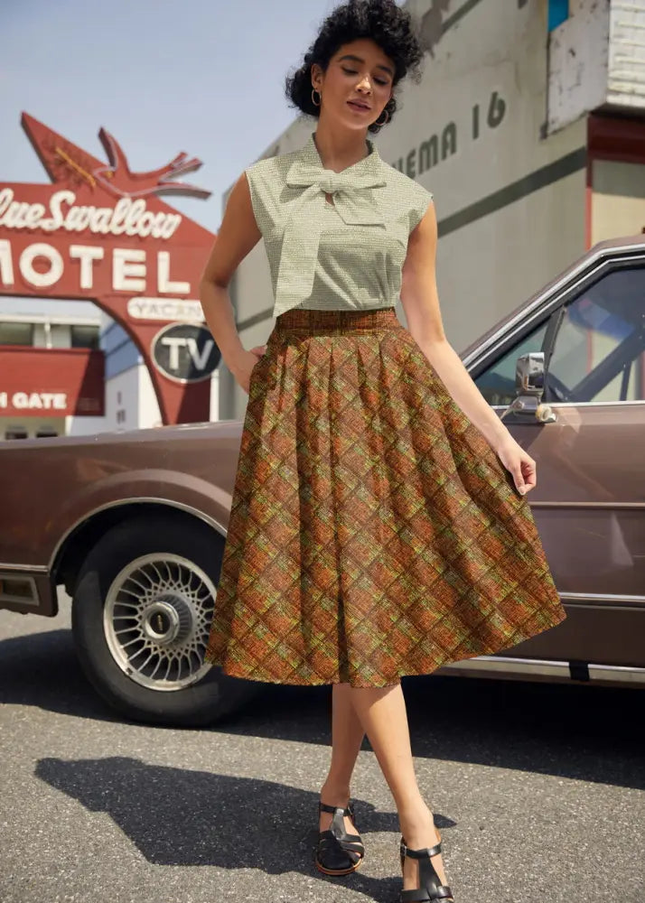 A vintage-style rust plaid Doris retro knee-length cotton skirt with pockets in warm rust and olive green tones