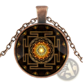 Bronze-toned sacred sri yantra pendant necklace with circular glass cabochon and intricate golden design on dark background