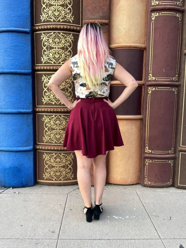 A flared maroon satin mini skirt with fitted waistband paired with a safari animal print bow neck cotton blouse