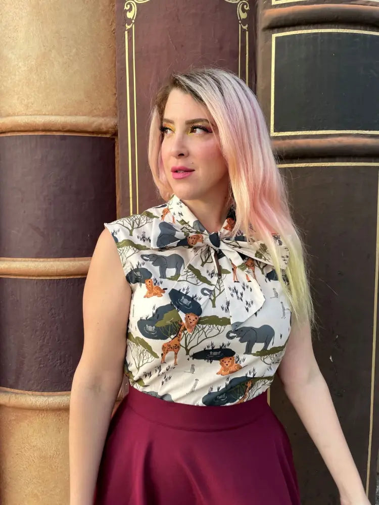 Sleeveless cotton blouse with white base and safari animal print featuring elephants giraffes lions and trees