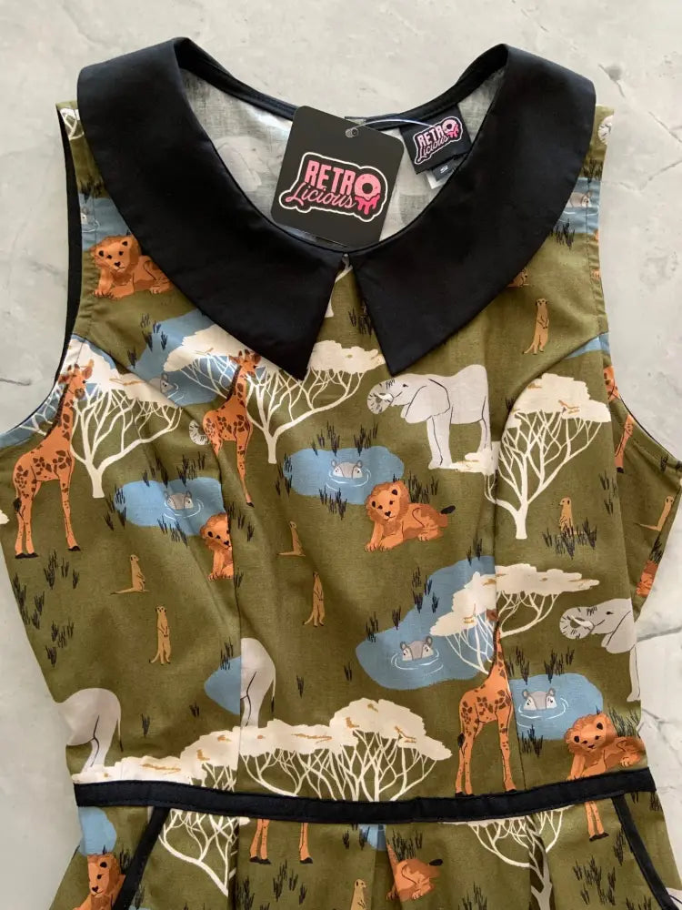 Olive green sleeveless cotton dress with black peter pan collar and safari print of giraffes lions elephants and meerkats