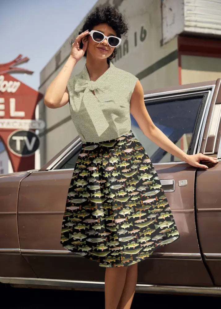 Black skirt with repeating fish pattern in green brown and beige paired with sage dot bow neck vintage cotton blouse