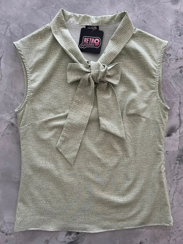 A sleeveless light green cotton blouse with subtle white dots and a matching fabric bow at the neckline