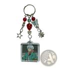 Clear acrylic saiki k beaded anime keychain with white hair character square portrait and dangling charms including stars and berries