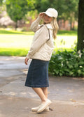 Beige quilted puffer vest with collar and front zipper paired with a sandra dark wash denim midi pencil skirt