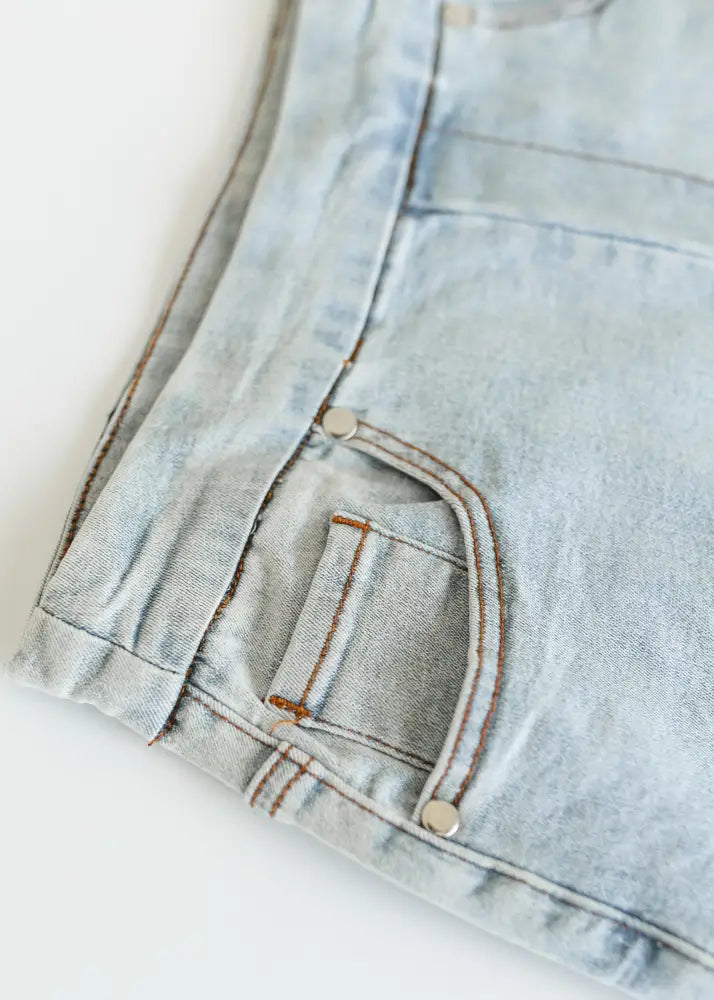 Sandra light wash denim stretch midi skirt featuring light-wash denim shorts with brown stitching and silver rivets