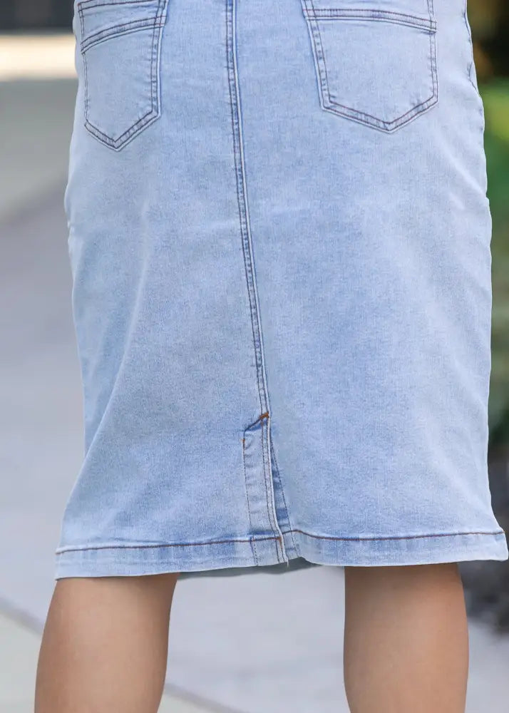 Sandra light wash denim stretch midi skirt back side showing two back pockets and a central seam detail