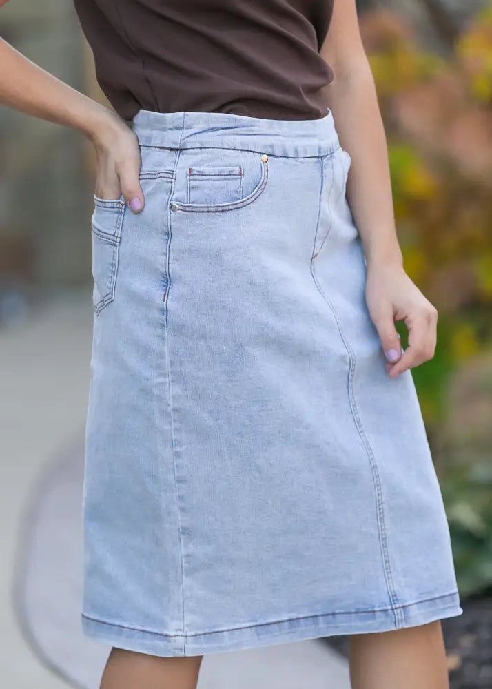 Sandra light wash denim stretch midi skirt with a classic a-line cut and front pockets in light-wash denim