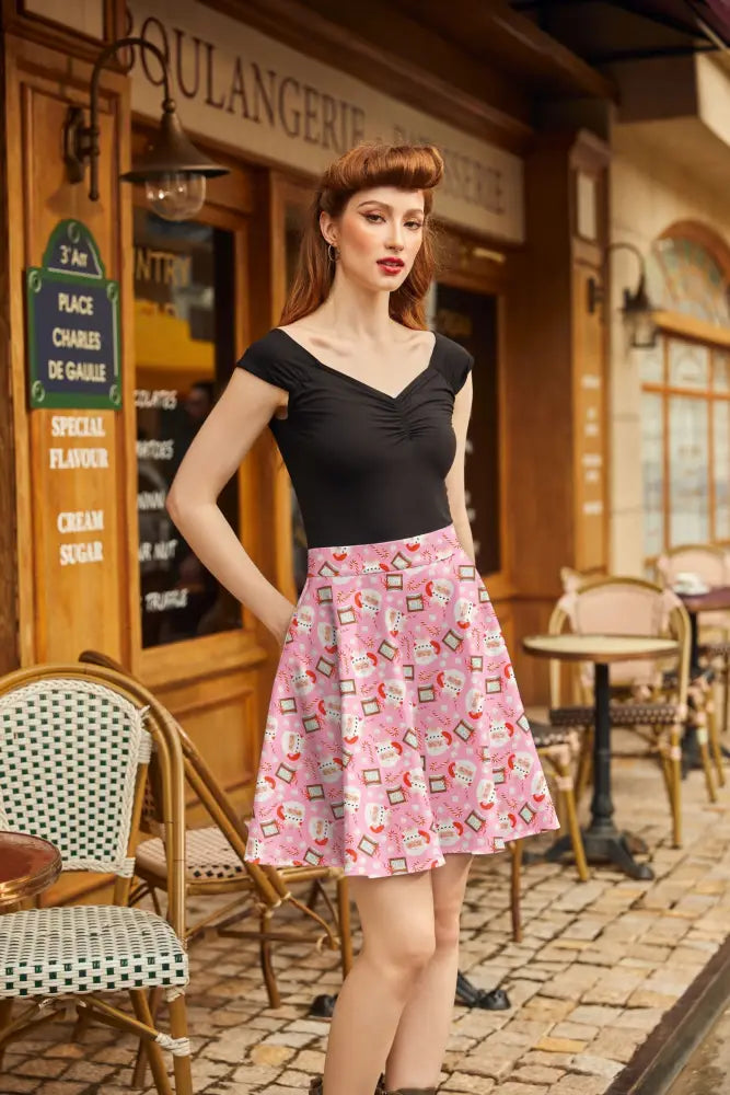 Pink pleated christmas skater skirt featuring a playful cartoon coffee cups and saucers pattern