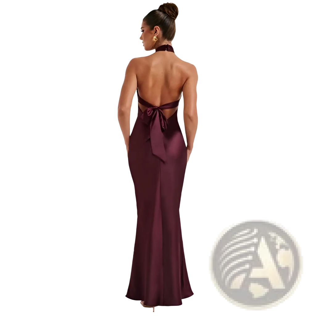 A sleek satin halter neck backless maxi dress in burgundy with a mermaid silhouette and back tie detail