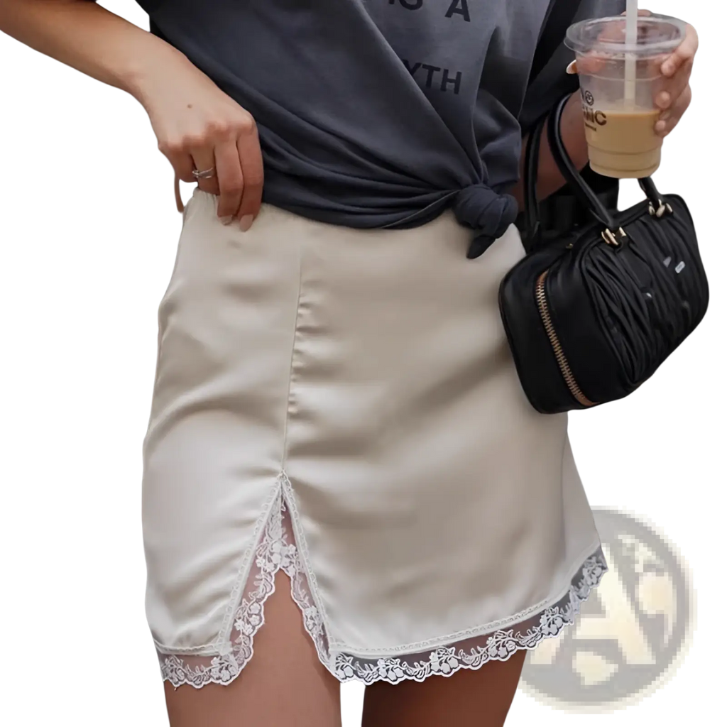 Cream-colored satin a-line mini skirt with delicate white lace trim along the hem for elegant wear