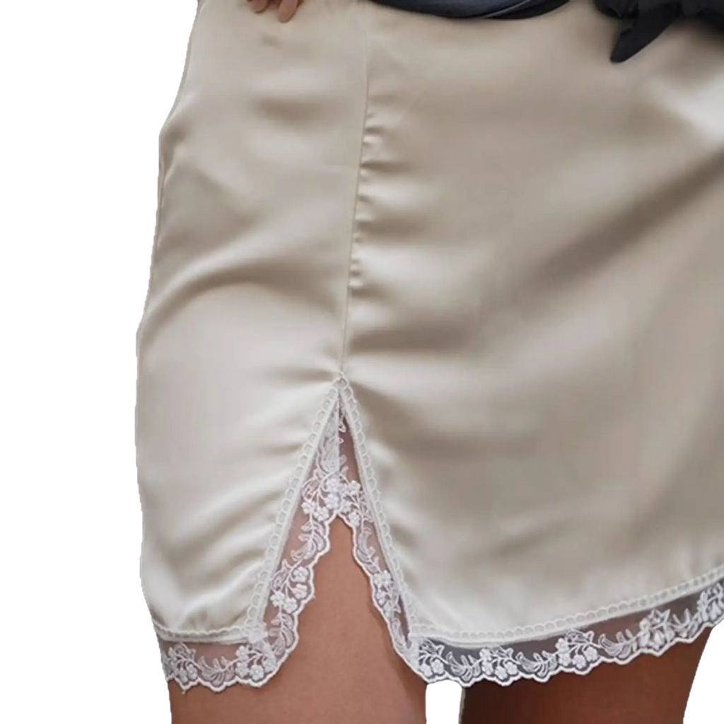 Cream-colored satin a-line mini skirt with delicate white floral lace trim along hem and side slit