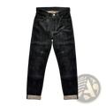 Dark indigo Saucezhan Fire Selvedge tapered raw denim jeans with faded textured finish and rolled cuffs showing lighter fabric