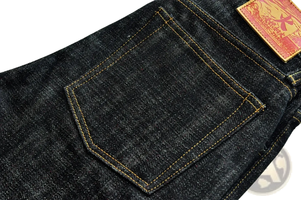 Back side of saucezhan fire selvedge tapered raw denim jeans in dark indigo with a red leather patch on the pocket