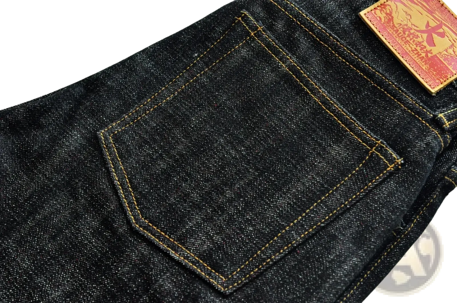 Back side of saucezhan fire selvedge tapered raw denim jeans in dark indigo with a red leather patch on the pocket